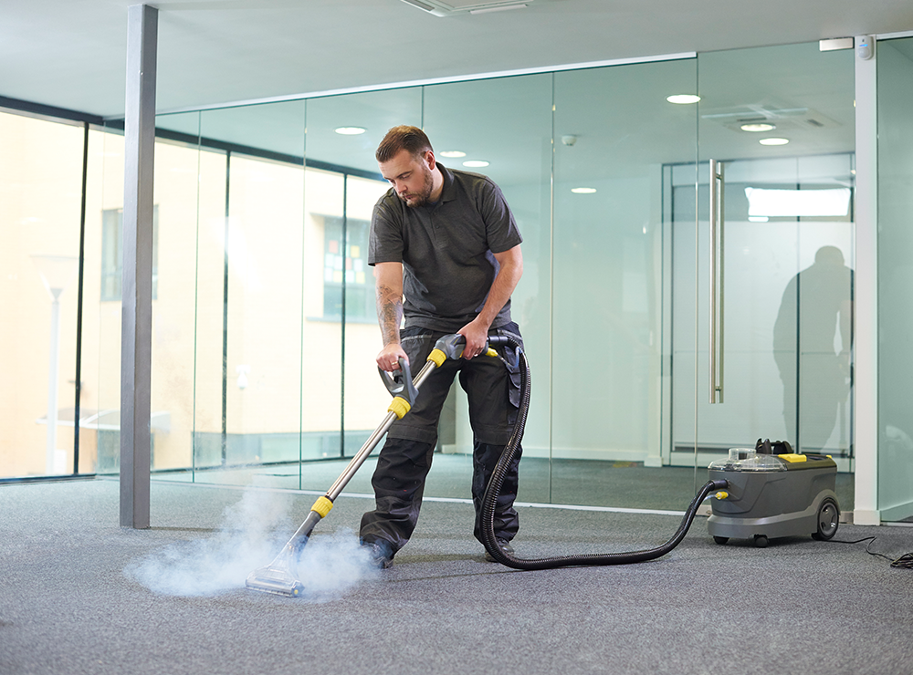 A man utilizes a vacuum cleaner on a carpet, emphasizing quality cleaning in Brisbane.