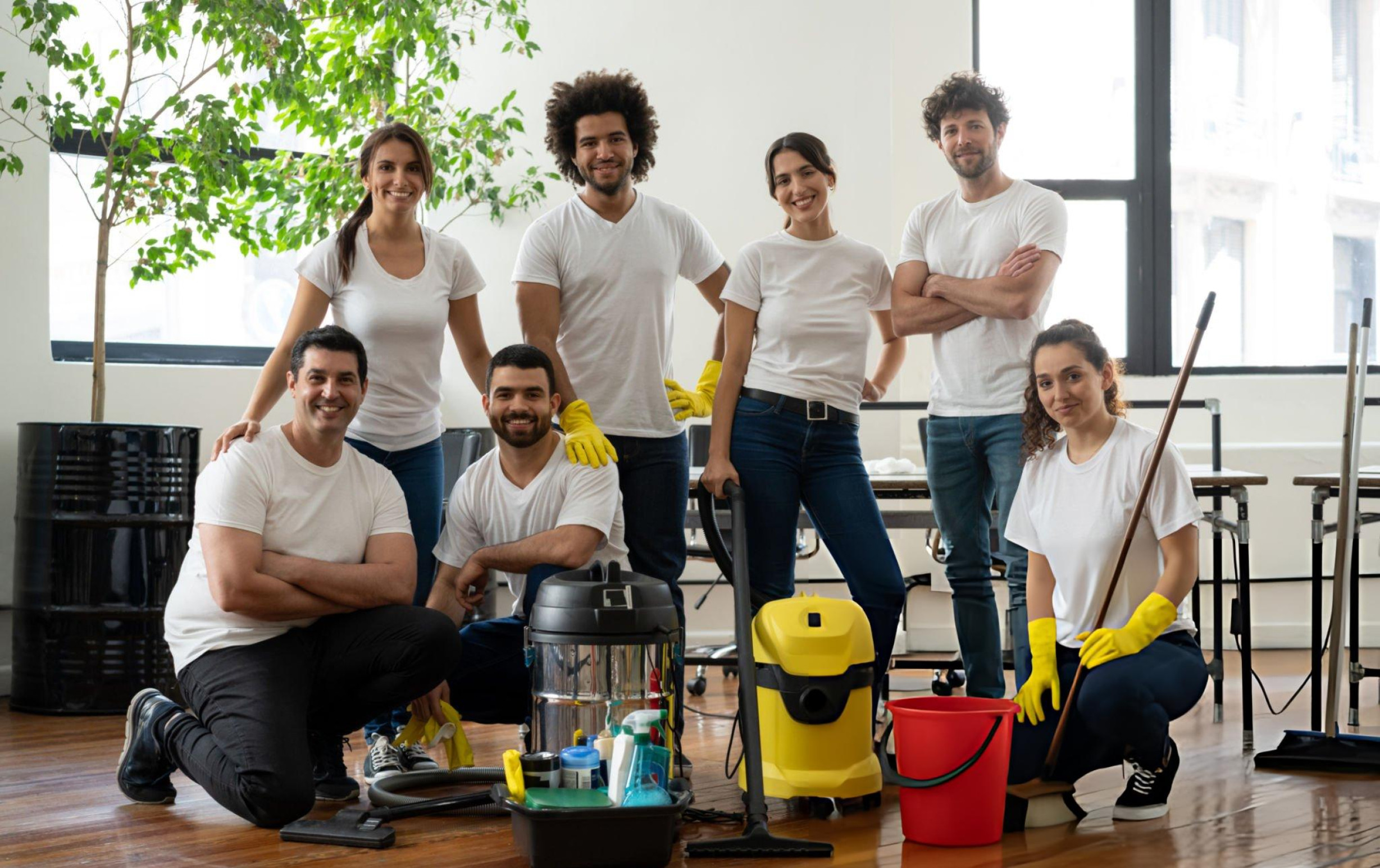 A group of smiling individuals holding cleaning supplies, promoting a Cleaning Service in Brisbane.